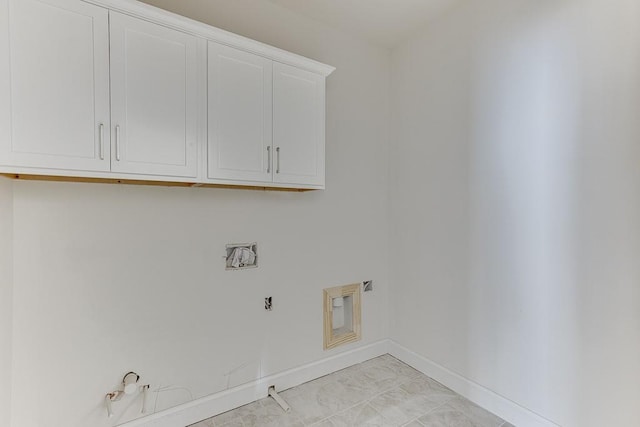 washroom with hookup for a gas dryer, light tile patterned floors, and cabinets