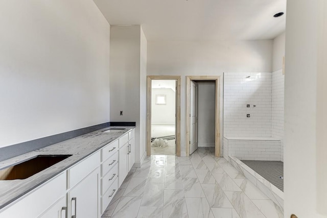 bathroom with tiled shower and vanity