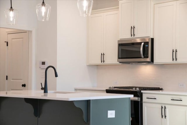 kitchen with light countertops, appliances with stainless steel finishes, backsplash, and a kitchen breakfast bar