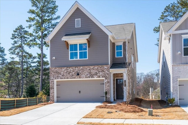 view of front of house featuring driveway, brick siding, an attached garage, and fence