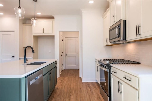 kitchen with light wood-style flooring, a sink, appliances with stainless steel finishes, backsplash, and crown molding