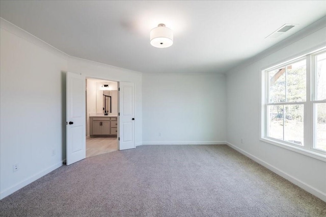 empty room featuring visible vents, baseboards, and light colored carpet