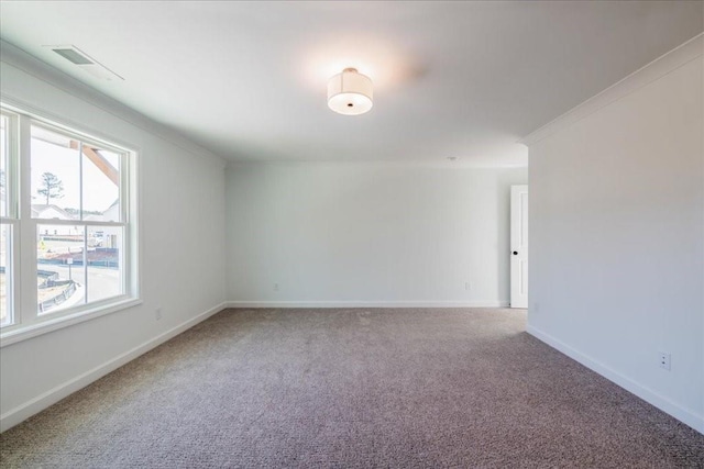 empty room featuring visible vents, crown molding, baseboards, and carpet flooring