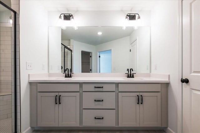 bathroom with double vanity, a stall shower, and a sink