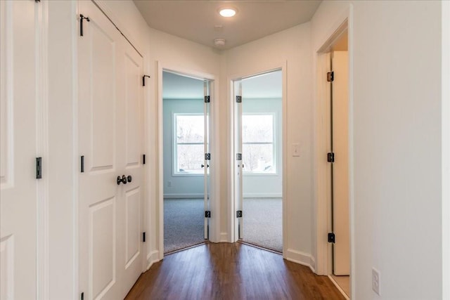 corridor featuring dark wood-style floors and baseboards