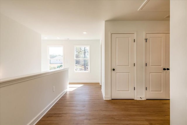 hallway featuring wood finished floors and baseboards