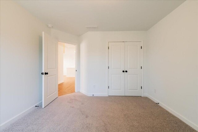 unfurnished bedroom with a closet, carpet, and baseboards