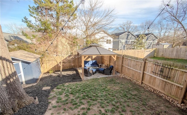 view of yard featuring an outbuilding, a fenced backyard, an outdoor living space, a gazebo, and a storage unit