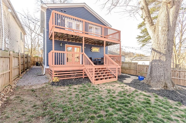 rear view of property with a fenced backyard and a deck