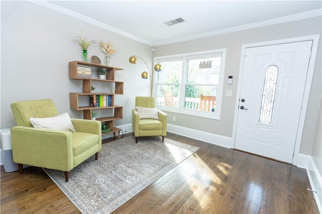 sitting room with baseboards, wood finished floors, visible vents, and crown molding