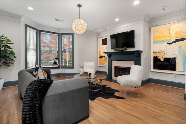 living area featuring baseboards, ornamental molding, wood finished floors, and visible vents