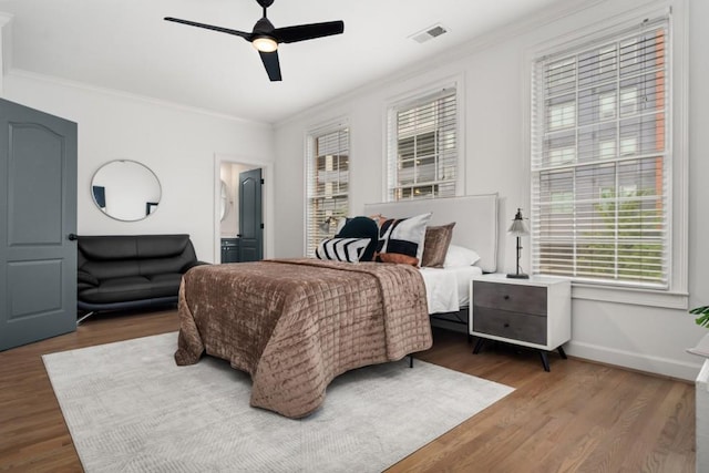 bedroom featuring ornamental molding, multiple windows, and visible vents