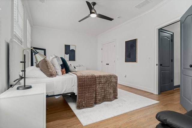 bedroom featuring ornamental molding, wood finished floors, and multiple windows