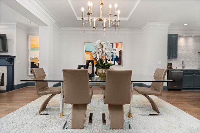 living room with baseboards, ornamental molding, wood finished floors, and a fireplace