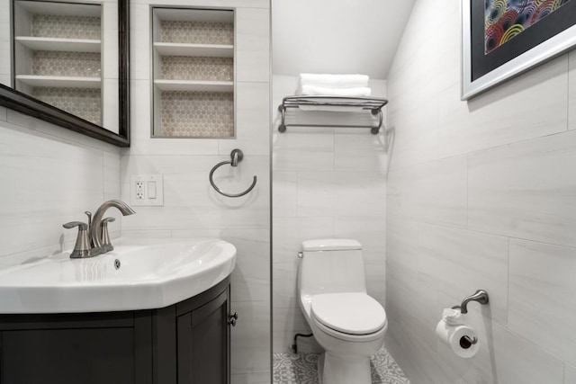 full bath featuring vanity, toilet, tile patterned floors, tile walls, and vaulted ceiling