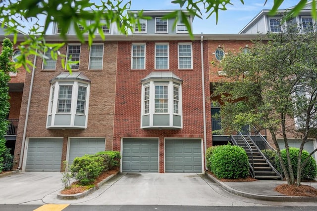 view of front of house featuring an attached garage, roof with shingles, driveway, and brick siding