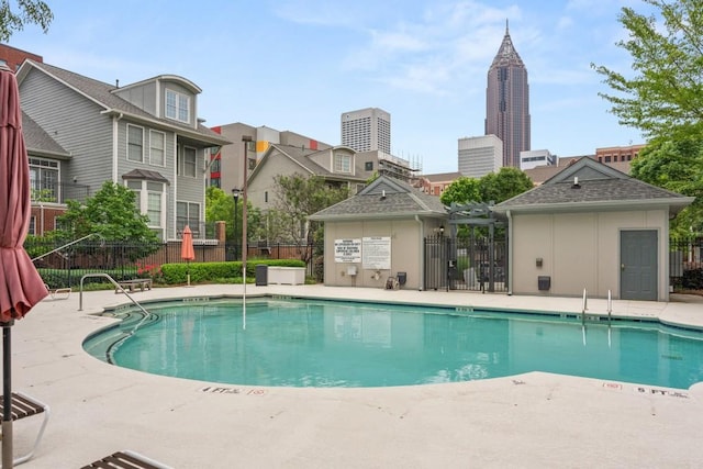 pool with a patio and fence