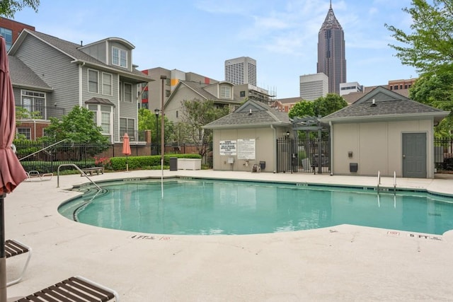 pool featuring fence and a patio
