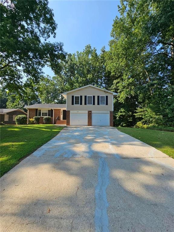 split level home featuring a garage and a front lawn