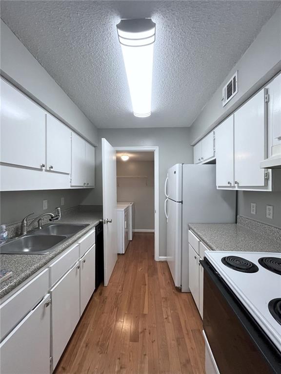 3020 Wingate Way, Sandy Springs, GA 30350 - kitchen featuring washing machine and dryer, white cabinets, a sink, and electric range oven