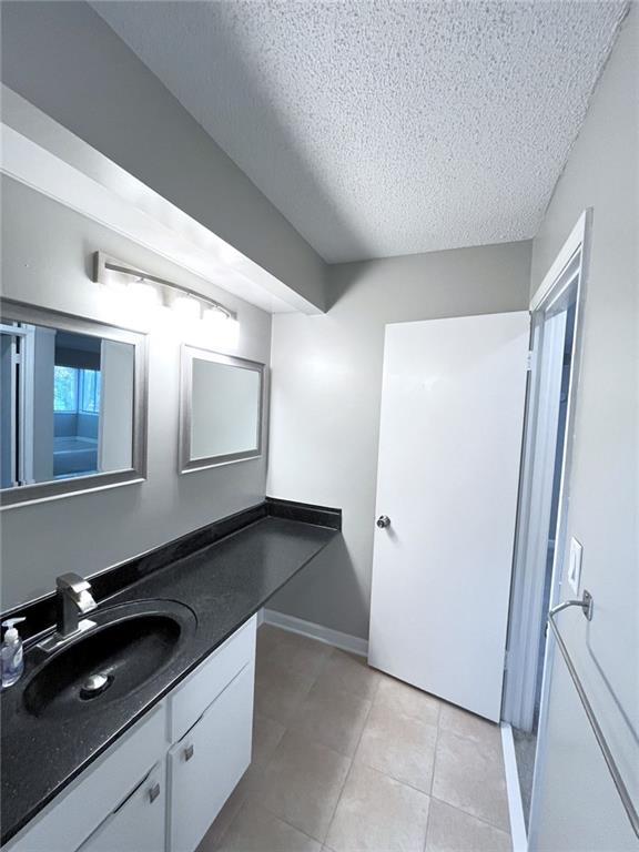 3020 Wingate Way, Sandy Springs, GA 30350 - bathroom featuring tile patterned flooring, a textured ceiling, baseboards, and vanity