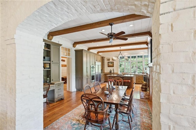 dining area featuring ceiling fan, beamed ceiling, and hardwood / wood-style floors