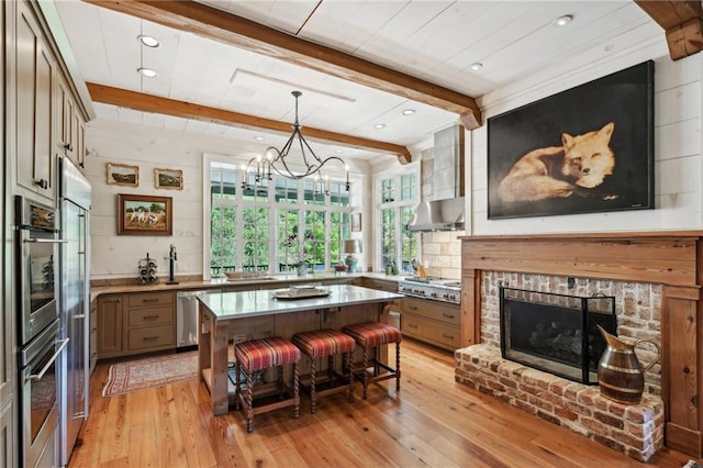 kitchen with a kitchen breakfast bar, light wood-type flooring, a center island, and beamed ceiling