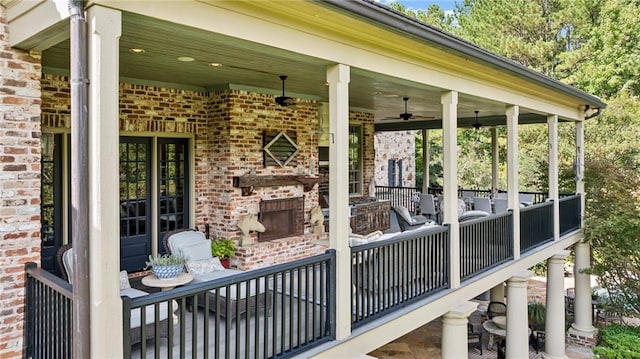 view of patio with an outdoor living space with a fireplace and ceiling fan