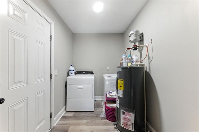 laundry room featuring light wood finished floors, water heater, separate washer and dryer, laundry area, and baseboards