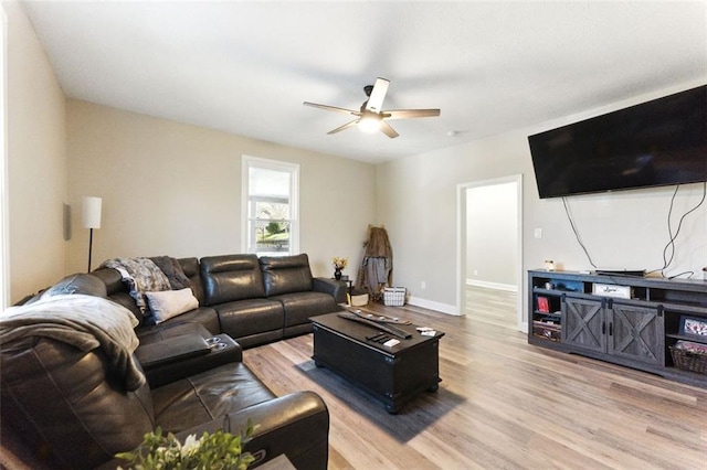 living room with wood finished floors, a ceiling fan, and baseboards