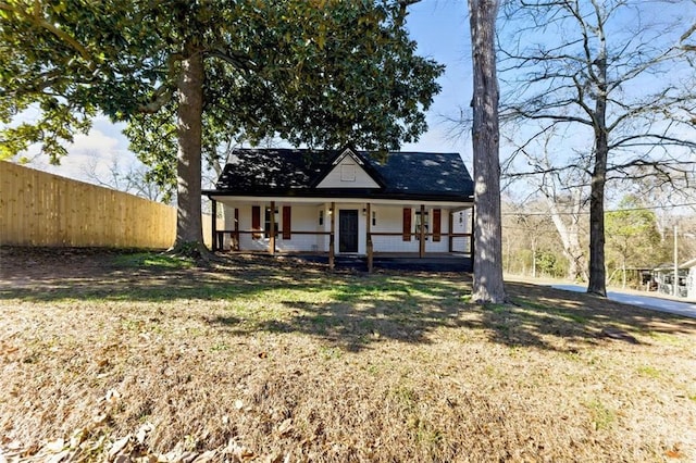 view of front facade featuring covered porch and fence