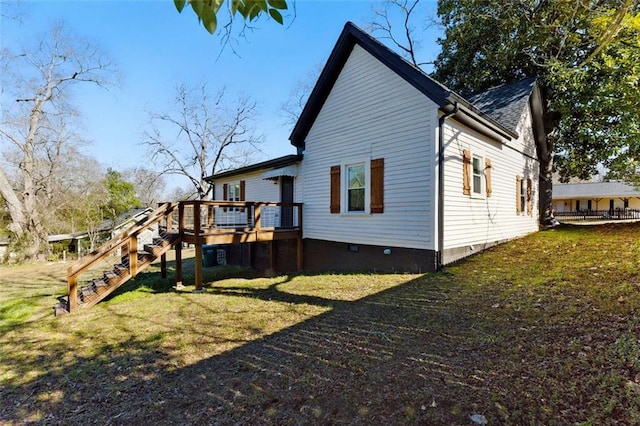 view of side of home with crawl space, a lawn, a deck, and stairs