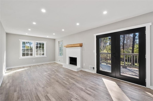 unfurnished living room featuring french doors, visible vents, light wood finished floors, and recessed lighting