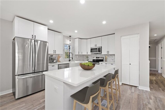 kitchen featuring open floor plan, a center island, freestanding refrigerator, and recessed lighting