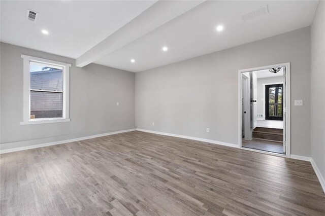 unfurnished room featuring wood finished floors, baseboards, a ceiling fan, and visible vents