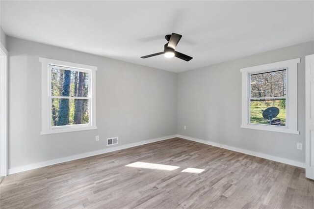 unfurnished bedroom with wood finished floors, ceiling fan, baseboards, and a spacious closet