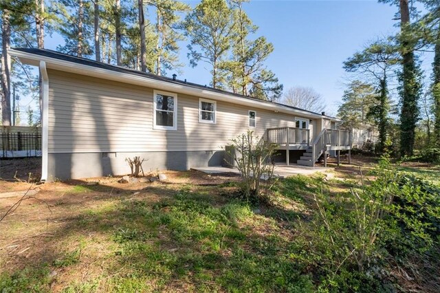 back of house featuring a patio area, a wooden deck, crawl space, and stairs