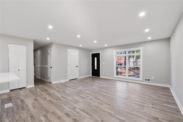 unfurnished living room featuring light wood-style floors, baseboards, visible vents, and recessed lighting