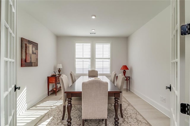 dining area featuring french doors and light wood-type flooring