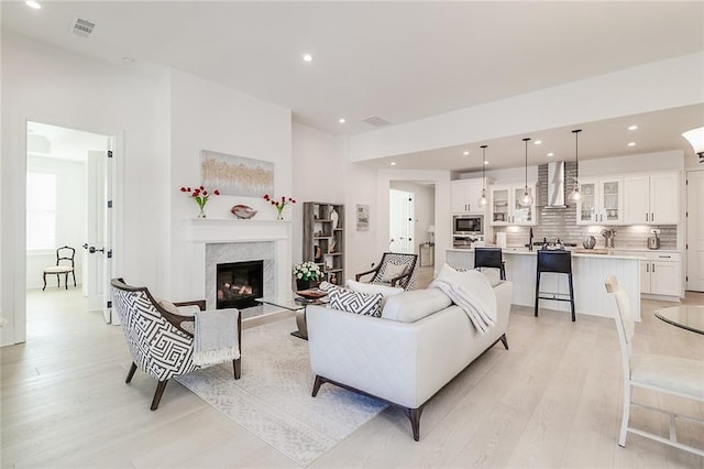 living room featuring a premium fireplace and light wood-type flooring