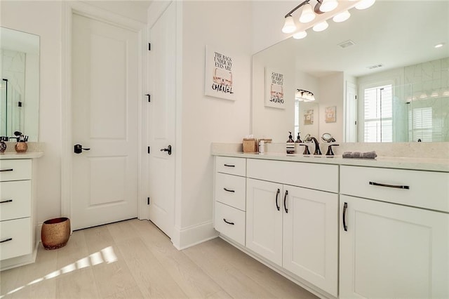 bathroom featuring walk in shower, wood-type flooring, and vanity