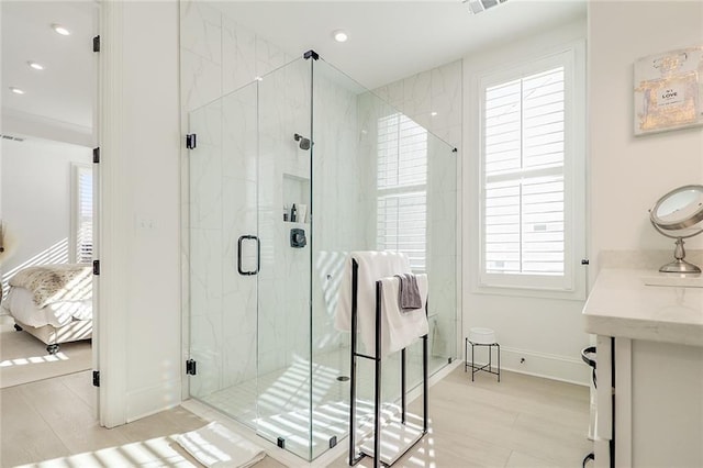 bathroom with a shower with door, vanity, hardwood / wood-style floors, and a wealth of natural light