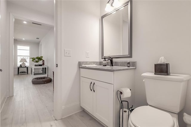 bathroom featuring vanity, hardwood / wood-style flooring, and toilet