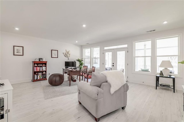 living room featuring french doors and light wood-type flooring