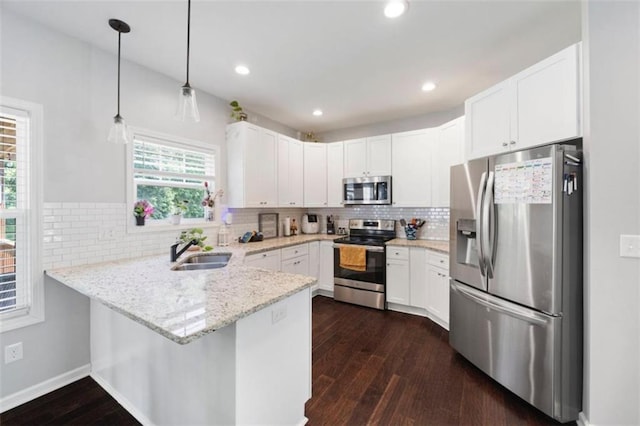 1016 Buckeye Ln, Villa Rica, GA 30180 - kitchen with stainless steel appliances, a peninsula, a sink, dark wood-type flooring, and light stone countertops