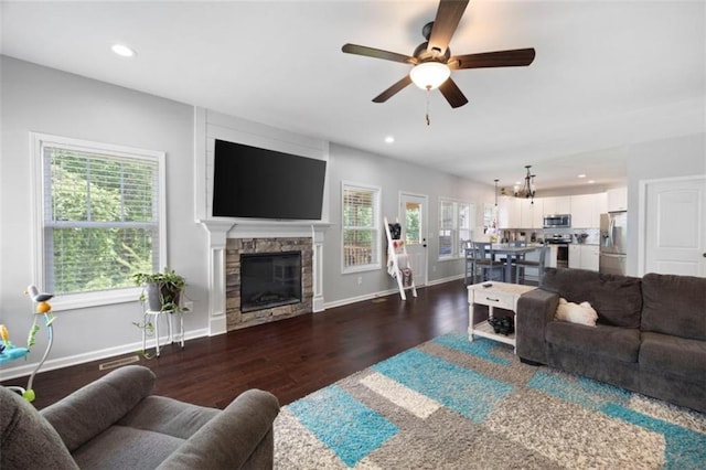 1016 Buckeye Ln, Villa Rica, GA 30180 - living area with wood finished floors, ceiling fan, baseboards, recessed lighting, and a stone fireplace