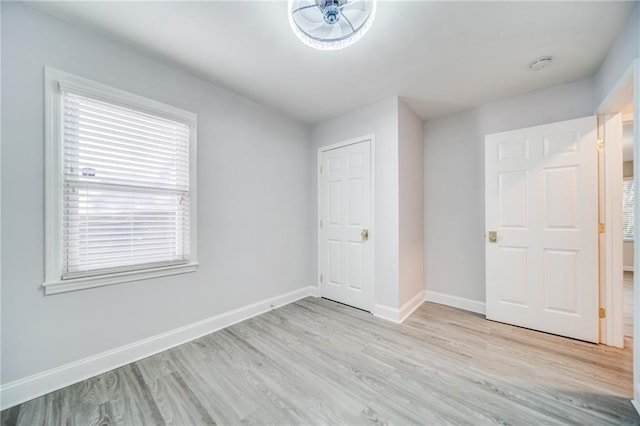 unfurnished bedroom with multiple windows and light wood-type flooring