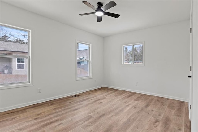 empty room with ceiling fan and light hardwood / wood-style flooring