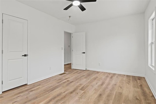 unfurnished bedroom featuring multiple windows, light hardwood / wood-style floors, and ceiling fan