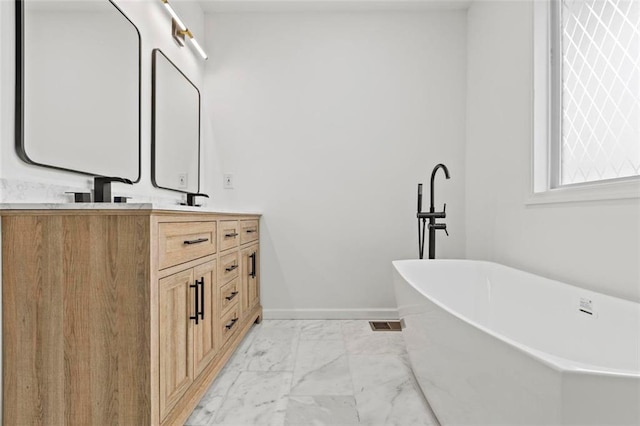 bathroom featuring vanity and a washtub